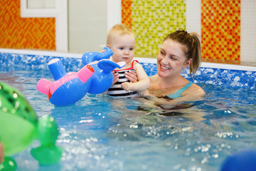 Female and child swim in water pool.