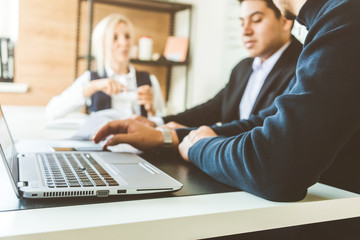A team of young businessmen working and communicating together in an office. Corporate businessteam and manager in a meeting.