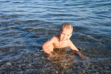 Fototapeta premium three year old little boy having fun at summer vacation in sea with his family