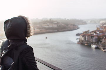 Unrecognizable traveler admiring river in city