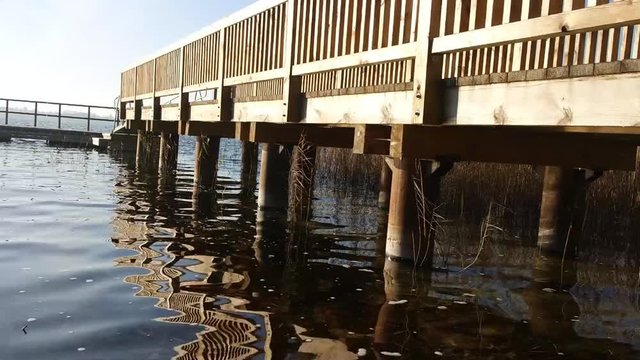 blue water of lake with wooden balls of pier