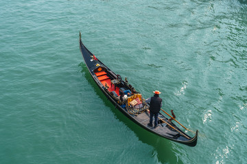 Tourists in gondolas on canal of Venice.