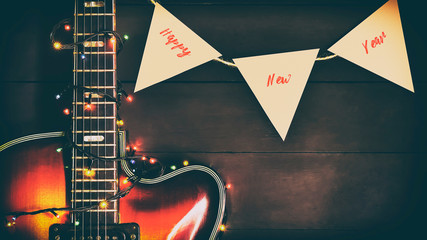 Old, jazz electric guitar with a luminous garland. New Year greeting card for musician, guitarist.