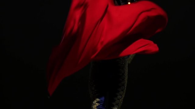 Torero in blue and gold suit or typical spanish bullfighter isolated spotlight on a black background. Close up, slow motion.