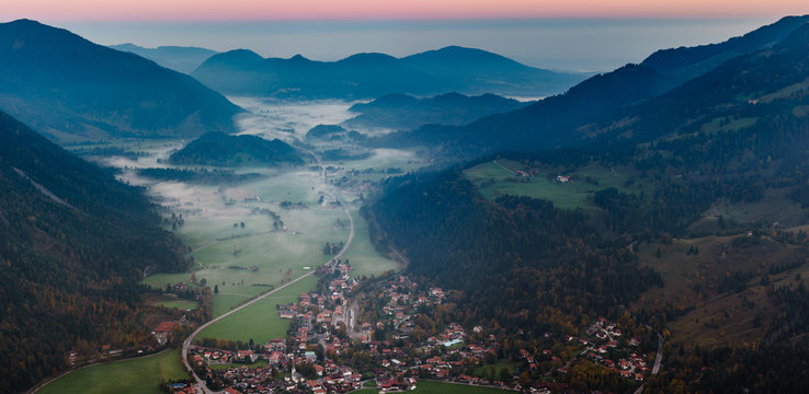 Bayrischzell municipality aerial view, with a view of Osterhofen town between the fog on Alpen road 307. German beautiful nature mountains and green forests, Bavaria, Germany