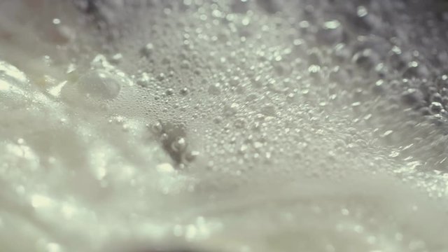 Extreme close up boiling broth with spoon