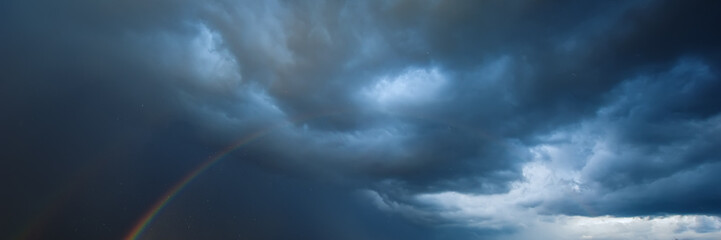 Fototapeta premium Rain clouds and rainbow. Summer season, August.