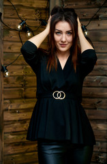 The concept of a glamorous portrait. Portrait of a pretty brunette girl in a black fashion suit on...