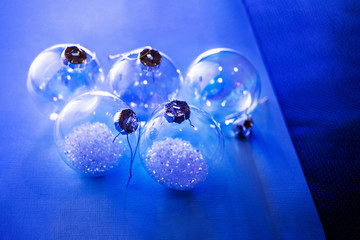 Five Christmas balls in bright neon light. Blue background.
