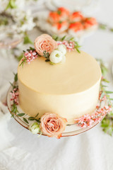 Fototapeta na wymiar White wedding cake with flowers decorations. Engagement party cake, anniversary cream cheese cake