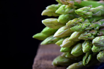 Bunch of raw green asparagus against black background