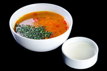 Uzbek Shurpa soup in a white bowl on a black background