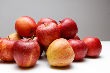 Fototapeta na wymiar Frische rote Äpfel gestapelt auf grauen Hintergrund