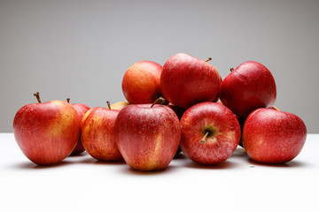 Frische rote Äpfel gestapelt auf grauen Hintergrund, seitliche Aufnahme