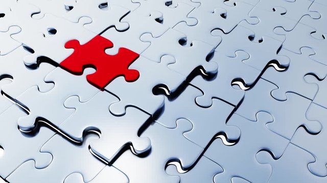 One large Red piece of puzzle taking its place among several silver pieces