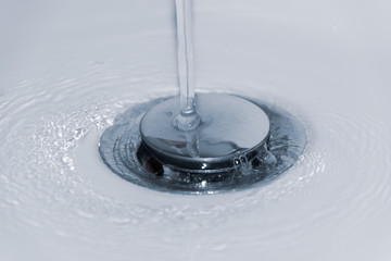 Wasser fliesst in den Ablauf