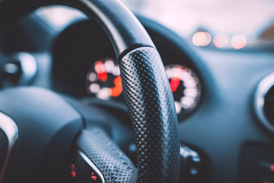 Close up shot of a steering wheel and speedometer in a car. Car dashboard. Dashboard details with indication lamps.Car instrument panel. Dashboard with speedometer, tachometer, odometer.