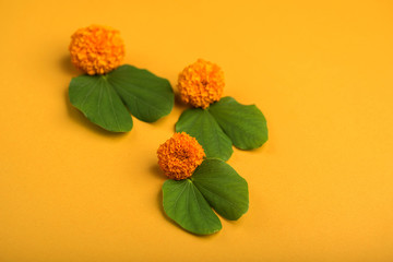 Indian Festival Dussehra, showing golden leaf (Bauhinia racemosa) and marigold flowers on a yellow...