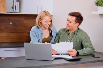 spouses sitting with laptop and documents, analyzing paperwork and house utility bills, financial issues, thoughtful couple consider papers managing finances and expenses, checking mail at home