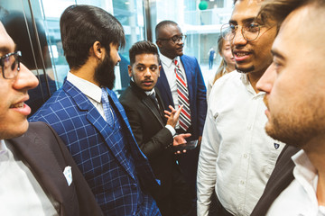 Business team group going on elevator. Business people in a large glass elevator in a modern office. Corporate businessteam and manager in a meeting.