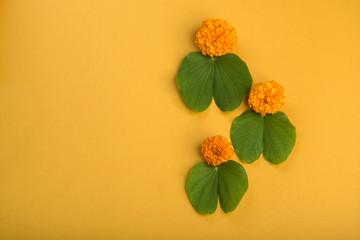 Indian Festival Dussehra, showing golden leaf (Bauhinia racemosa) and marigold flowers on a yellow...