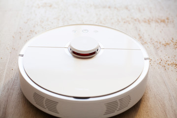 Robot vacuum cleaner performs automatic cleaning of the apartment at a certain time. Smart home.