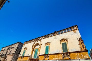 Scenic sight, street view from the beautiful town of Locorotondo, Bari province, Apulia, Puglia , Southern Italy. Old buildings fronts on the central street