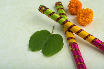 Indian Festival Dussehra, showing golden leaf (Bauhinia racemosa) and marigold flowers with Dandiya sticks.
