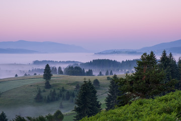 Sunrise on the mountain with morning fog in the valley.