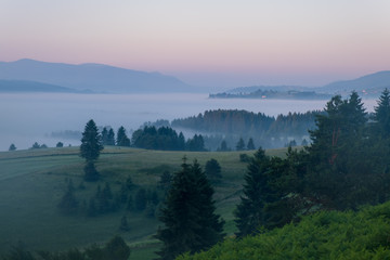 Sunrise on the mountain with morning fog in the valley.