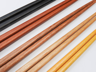 High angle view of five pairs wooden chopsticks are arranged isolated on white background. Main tableware in East and Southeast Asia. Traditional culture and lifestyle concept.