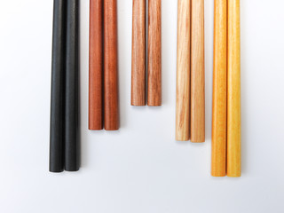 Top view of five color wooden chopsticks are arranged in parallel isolated on white background. Main tableware in East and Southeast Asia. Traditional culture and lifestyle concept. With copy space.