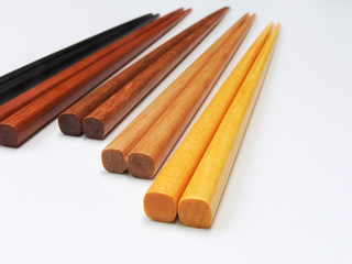 High angle view of five pairs wooden chopsticks are arranged isolated on white background. Main tableware in East and Southeast Asia. Traditional culture and lifestyle concept. With copy space.