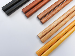 Top view of five color wooden chopsticks are arranged isolated on white background. Main tableware in East and Southeast Asia. Traditional culture and lifestyle concept. With copy space.