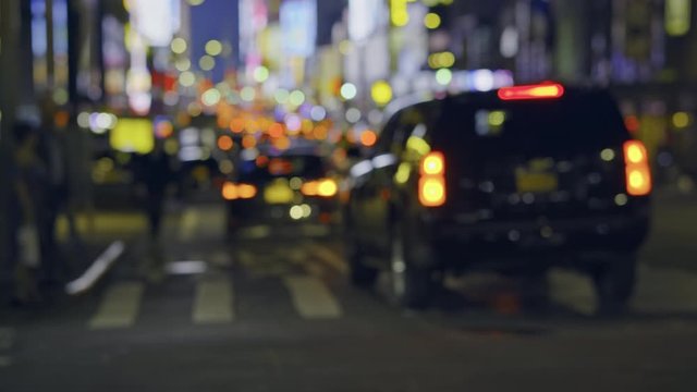 New York City street traffic at night, commuting cars and pedestrians, colorful lights blurry image 
