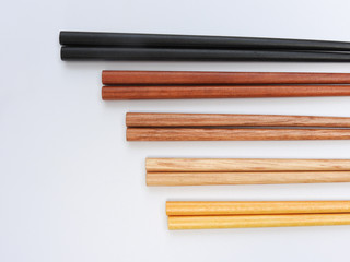 Top view of five color wooden chopsticks are arranged in parallel isolated on white background....