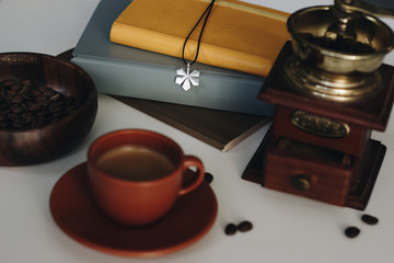 Books, cup of coffee, coffee beans and vintage coffee grinder