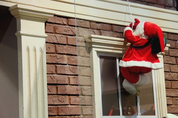 Santa Claus descends a rope from roof
