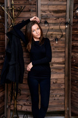 Full-length portrait. Photo in a stylish interior in the studio of a pretty glamorous brunette, a girl in a black T-shirt with long hair on a color alternative fashionable original background.