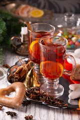 Two glasses with mulled wine on a tray with christmas accessories