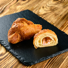 cut croissant with filling on a wooden rustic background