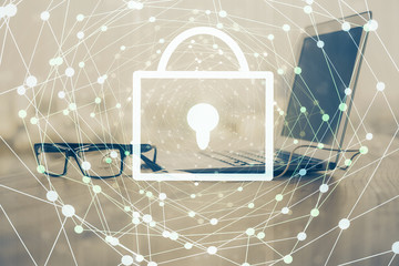 Double exposure of desktop with computer and lock icon hologram. Concept of data safety.