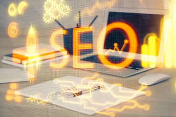 Multi exposure of table with computer and seo drawing hologram. Search optimization concept.