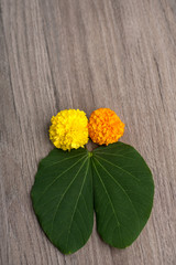 Indian Festival Dussehra, showing golden leaf (Bauhinia racemosa) and marigold flowers on a wooden...