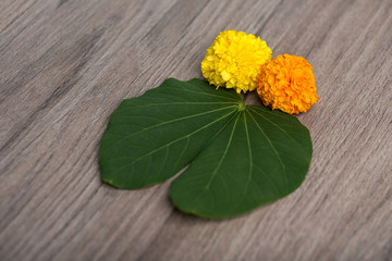 Indian Festival Dussehra, showing golden leaf (Bauhinia racemosa) and marigold flowers on a wooden...