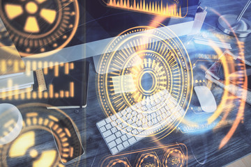 Computer on desktop in office with technology theme hologram. Multi exposure. Tech concept.