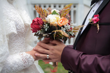 wedding bouquet in brides hands of bride and groom