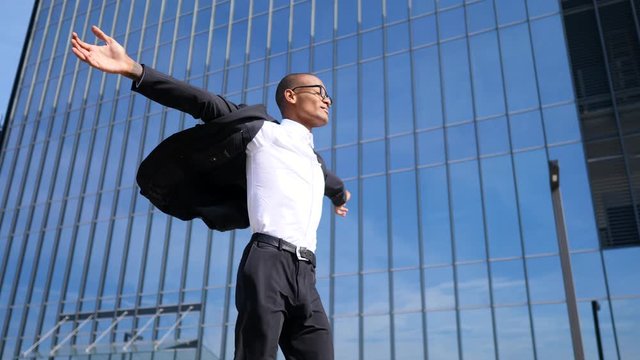 Young Businessman With Arms Wide Open Walking In City
