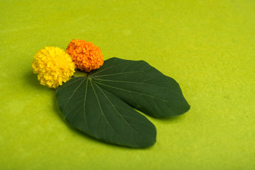 Indian Festival Dussehra, showing golden leaf (Bauhinia racemosa) and marigold flowers on a Brown...