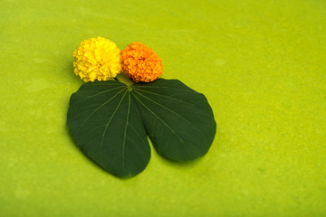 Indian Festival Dussehra, showing golden leaf (Bauhinia racemosa) and marigold flowers on a Brown...